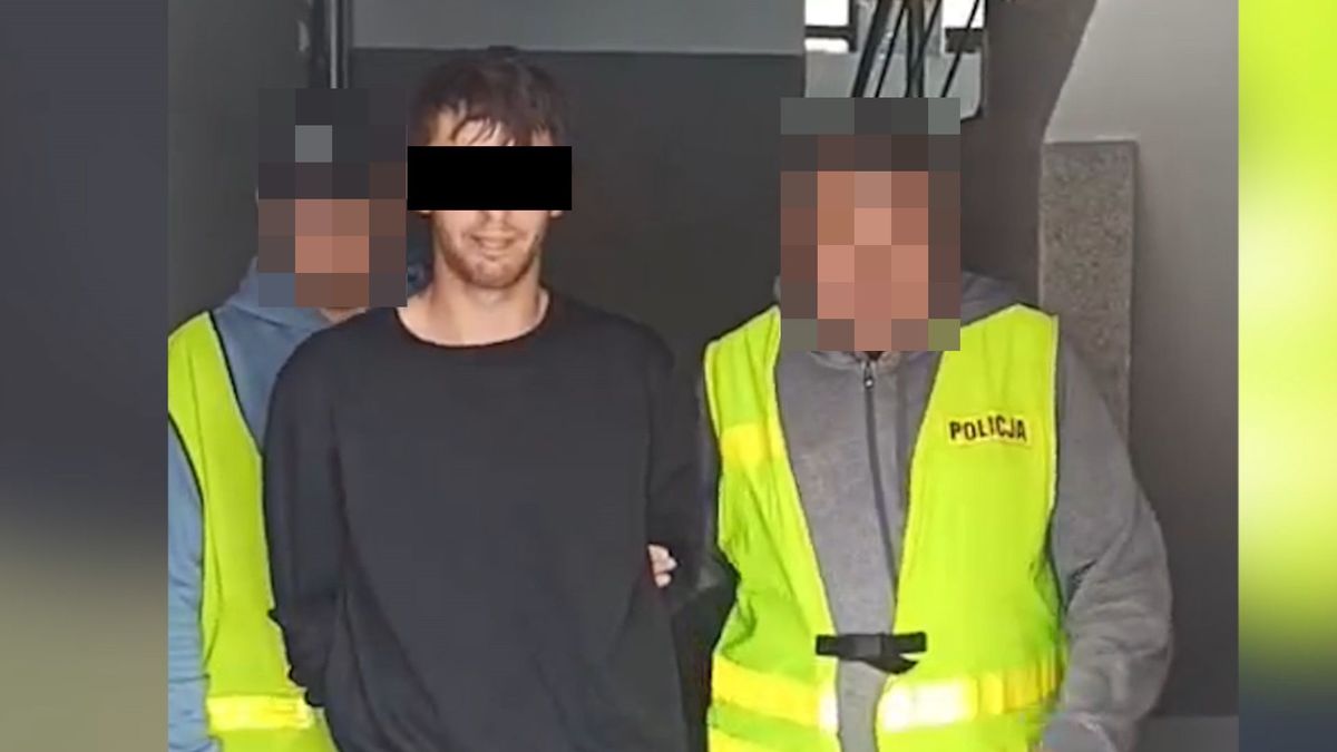 Policjanci prowadzą zatrzymanego mężczyznę.