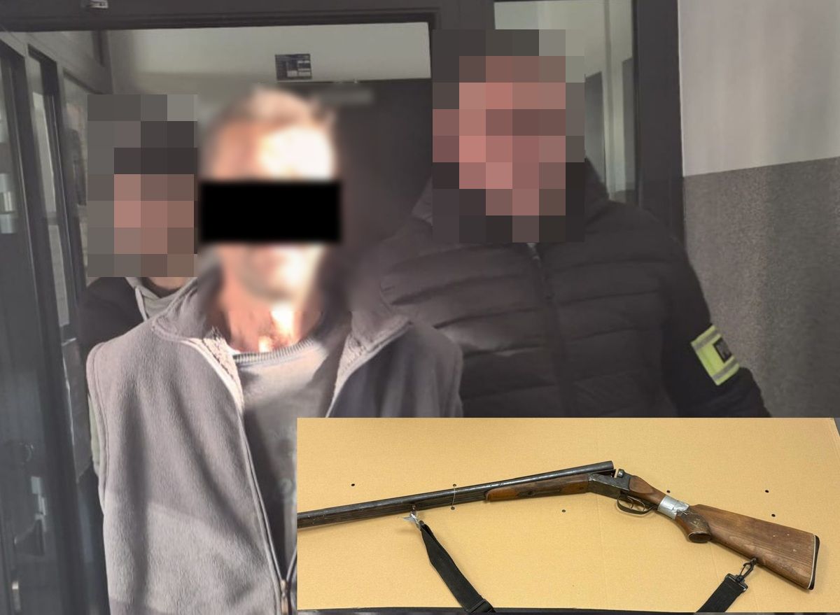 Policjanci prowadzą zatrzymanego mężczyznę. W dolnej części zdjęcia zabezpieczona broń myśliwska.