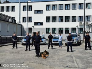 umundurowani policjanci stoją na tle budynku komendy