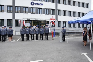 przed budynkiem komendy powiatowej policji w Opolu Lubelskim trwają uroczyste obchody święta policji. Komendant Powiatowy Policji w Opolu Lubelskim przemawia do zgromadzonych. W tle widać uczestniczących w spotkaniu policjantów oraz zaproszonych gości.