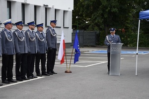 scena z uroczystych obchodów święta policji. Komendant Powiatowy Policji w Opolu Lubelskim przemawia do zgromadzonych. w tle widać uczestniczących w spotkaniu policjantów.