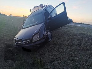 ciemny samochód opel stoi przodem w rowie. przód samochodu jest rozbity