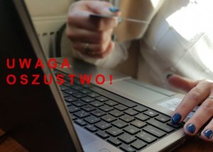 czerwony napis oszust internetowy. w tle wizerunek siedzącego przed laptopem człowieka trzymającego w ręku kartę płatniczą.