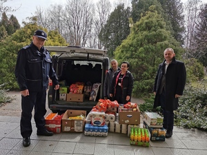 przedstawiciele komendy powiatowej policji w opolu lubelskim stoją przy kartonach z artykułami spożywczymi