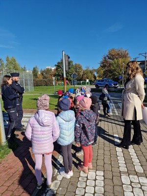 policjanci rozmawiają ze zwróconymi w ich kierunku dziećmi