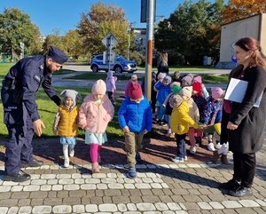 policjant wyjaśnia sposób przechodzenia przez jezdnię