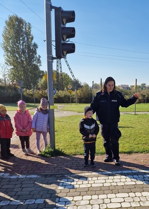 policjantka wyjaśnia dzieciom jak prawidłowo przechodzić przez jezdnię