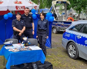 policjanci przy stoliku z akcesoriami policyjnymi