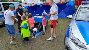 dzieci z policjantką rozdającą cukierki