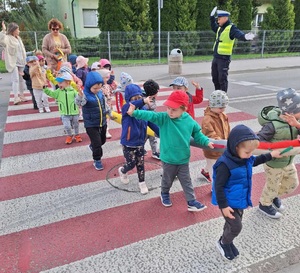 dzieci przechodzą przez ulicę z policjantem