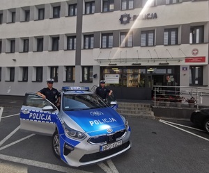 policjanci i oznakowany radiowóz policyjny