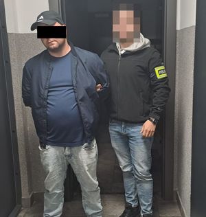 policjant z zatrzymanym mężczyzną