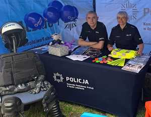policjantka daje dziecku element odblaskowy