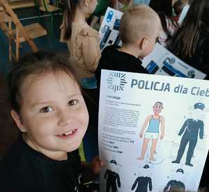 Dziecko trzymające wycinankę przedstawiającą policjanta