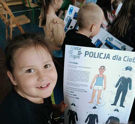 Dziecko trzymające wycinankę przedstawiającą policjanta
