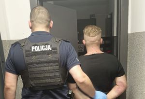 policjant z zatrzymanym mężczyzną