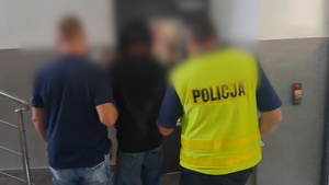 policjanci prowadzą zatrzymanego mężczyznę