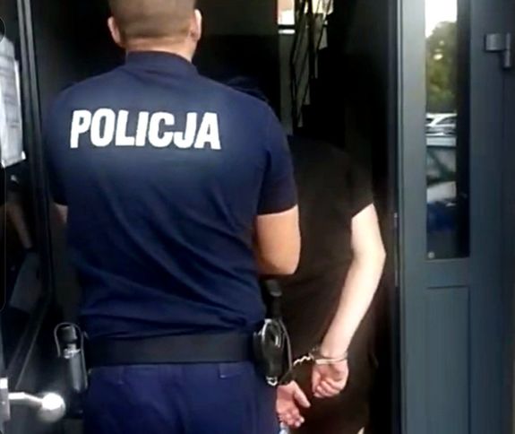 policjant prowadzi zatrzymanego 29-latka