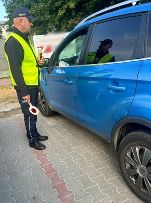 policjant stojący przy samochodzie
