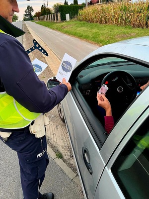 policjant wręczający ulotkę