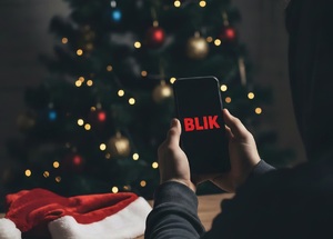 osoba trzymająca telefon w tle choinka