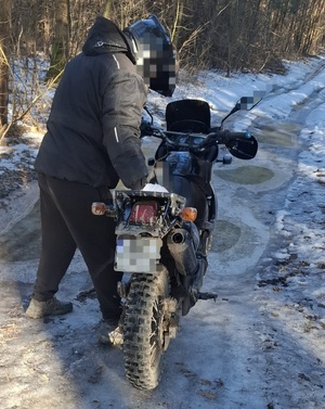 motocyklista stoi przy motocyklu