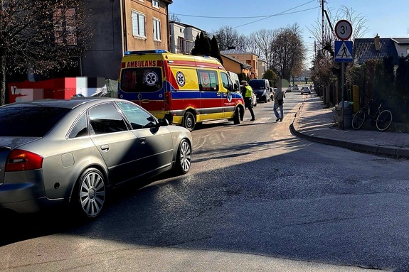 skrzyżowanie z widocznym samochodem, karetką i rowerem