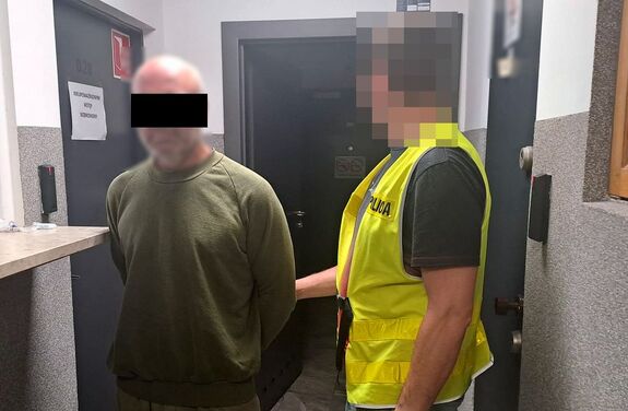 policjant z zatrzymanym mężczyzną