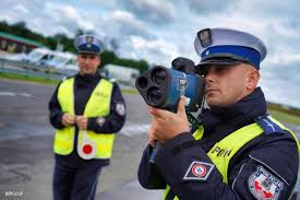 policjant trzymający urządzenie do pomiaru prędkości pojazdów
